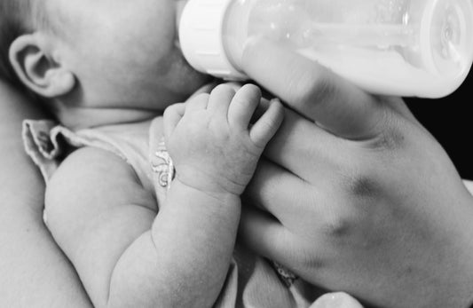 Baby being fed by a feeding bottle