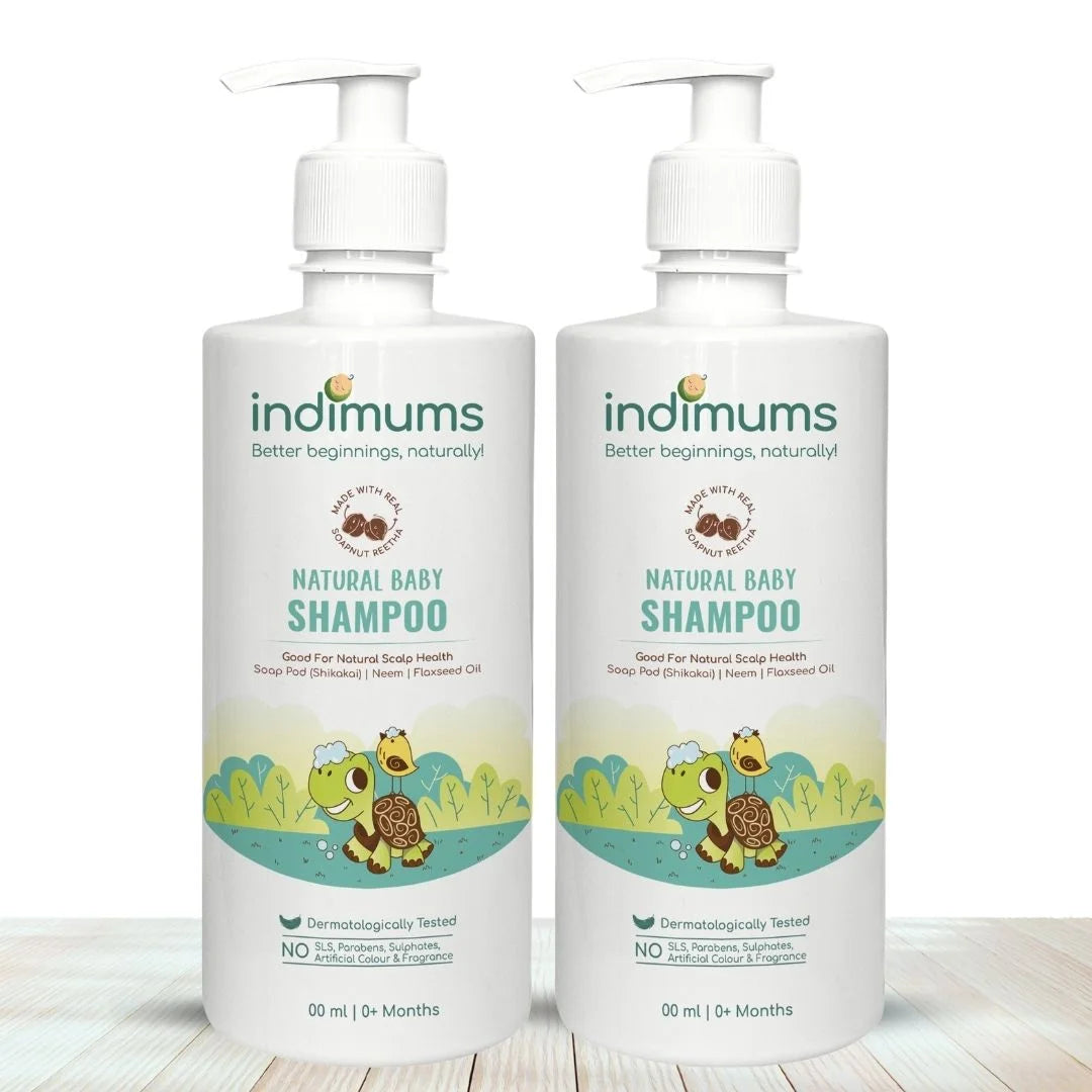 Two bottles of Indimums Natural Baby Shampoo (500 ML) on a wooden surface with a white background
