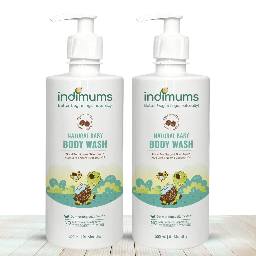 Two bottles of Indimums Natural Baby Body Wash (500 ML) on a wooden surface with a white background