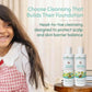 Child with long hair next to Indimums baby shampoo and body wash bottles on a wooden surface.