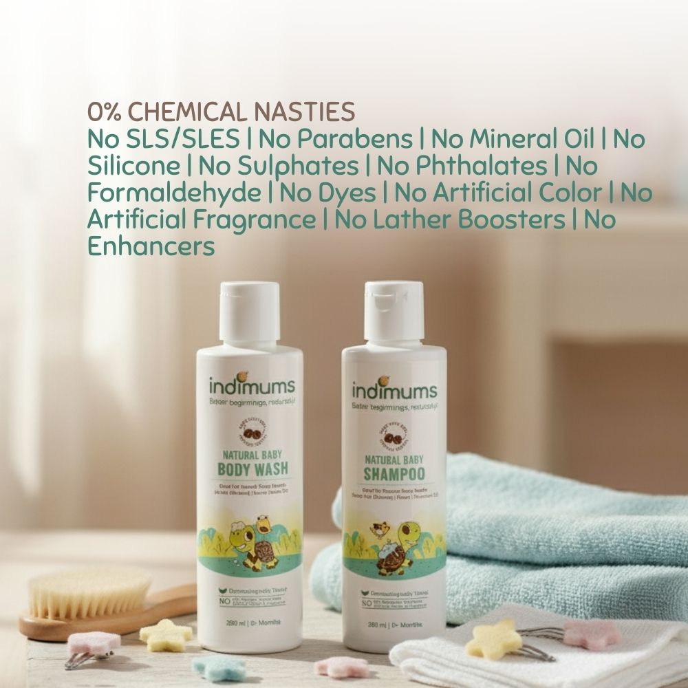 Two bottles of Indimums natural baby shampoo & baby body wash on a wooden surface with a towel and bath items in the background.