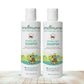 Two bottles of indimums natural baby shampoo on a wooden surface with a white background