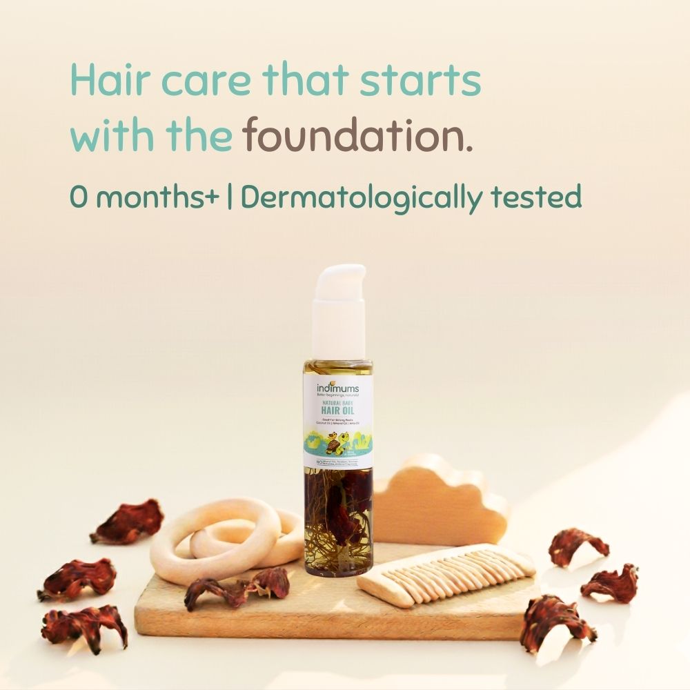 Bottle of Indimums hair oil with natural ingredients on a wooden board against a light background