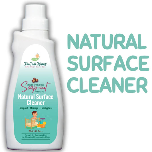 A white bottle of "The Indi Mums" Natural Surface Cleaner with soapnut (Reetha) ingredients, featuring a teal gradient label with product information and a cartoon illustration of a child playing with toys. Large text on the right reads "NATURAL SURFACE CLEANER" in teal letters.