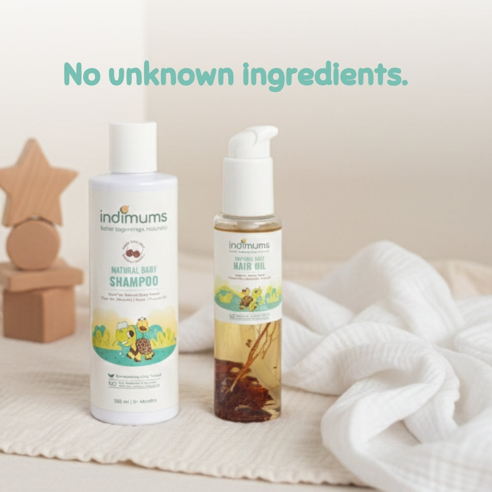 Two bottles of Indimums Hair Oil & Shampoo on a soft surface with a neutral background.