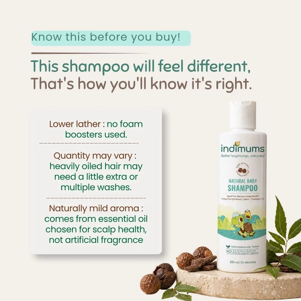 A bottle of indimums Natural Baby Shampoo displayed on a light beige background with informational text on the left and decorative acorns and leaves on a stone slab at the bottom right.
